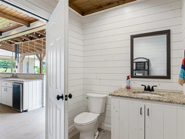 a bathroom with a granite countertop sink toilet and mirror
