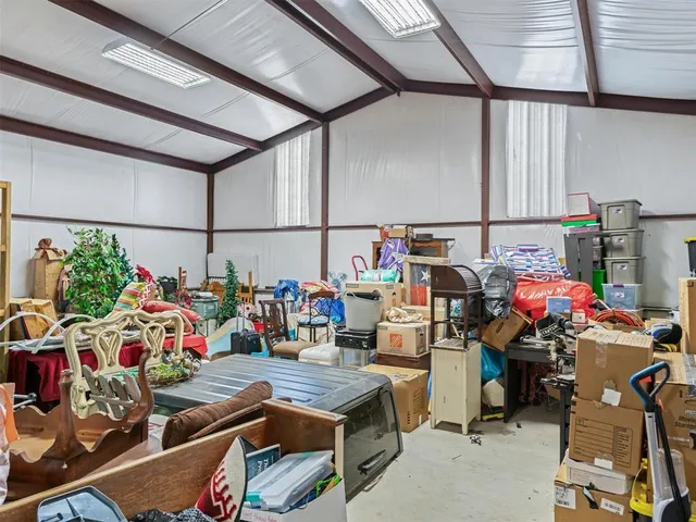 a storage area with lots of clutter and chairs