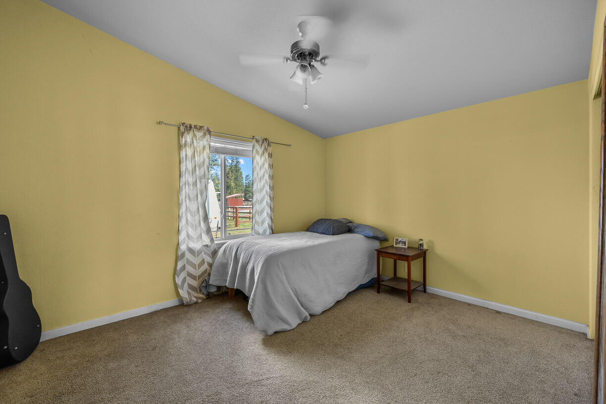 67500 Harrington Loop Road Bend, OR 97703 - Photo 21 of 72 a bedroom with a bed and a ceiling fan