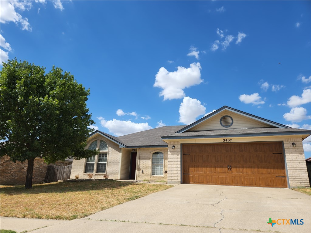 a front view of a house with a yard and potted plants