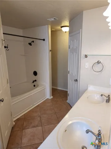 a bathroom with a tub a sink and a shower