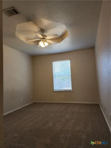 an empty room with a window and a ceiling fan