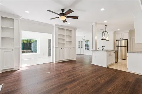 a view of a kitchen with wooden floor and electronic appliances