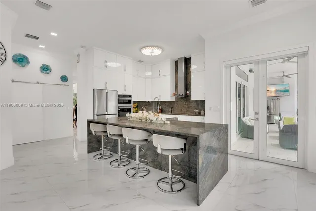 a kitchen with a sink and chairs