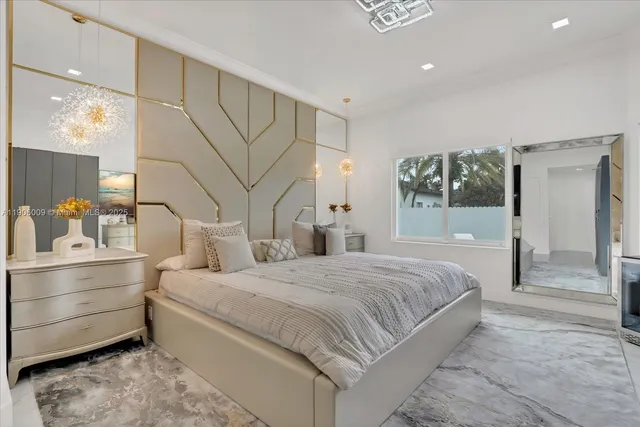 a bedroom with a large bed and a chandelier