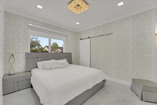 a bedroom with a large bed and a chandelier