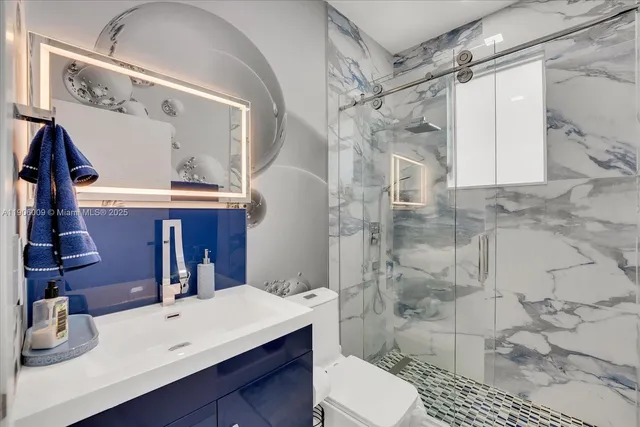 a bathroom with a sink a toilet and shower