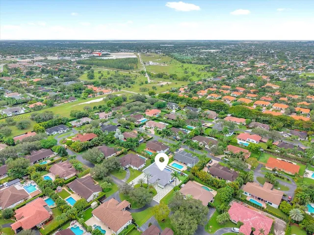 an aerial view of residential houses with outdoor space and street view