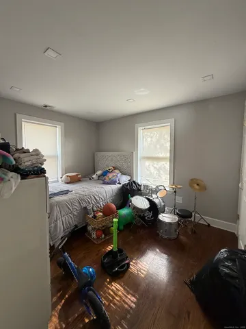 a bedroom with bed couch and window