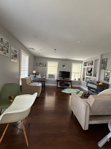 a living room with furniture a rug a lamp and a window