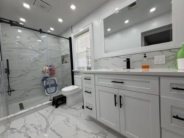 a bathroom with a toilet sink double vanity and mirror