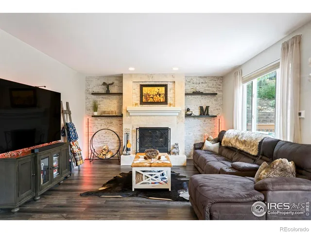 a living room with furniture a flat screen tv and a fireplace