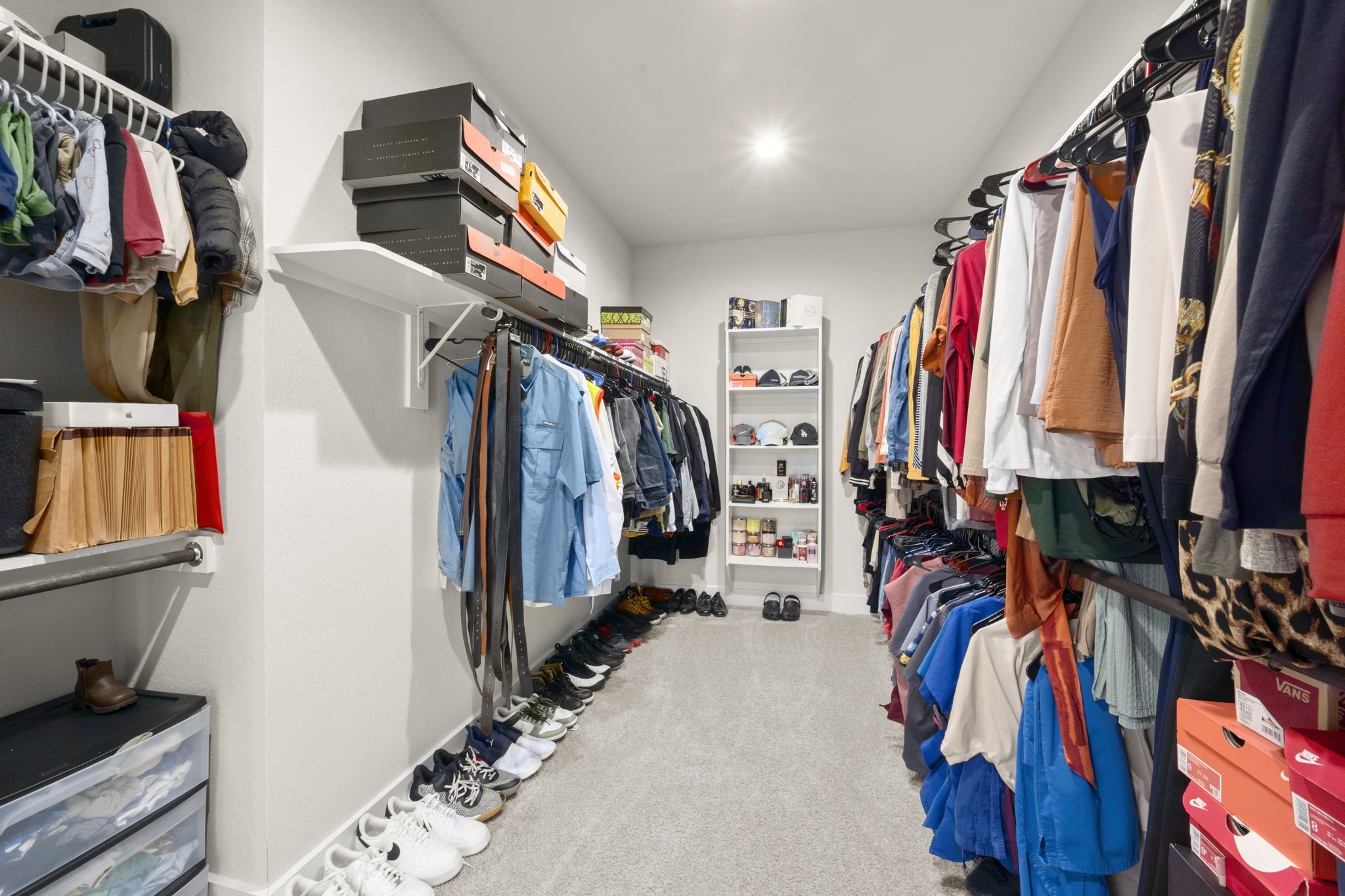 24715 Native Forest Spring, TX 77373 - Photo 23 of 37 Spacious walk-in closet with ample hanging space, shelving for shoes and accessories, and bright lighting. Perfect for organizing a large wardrobe efficiently.