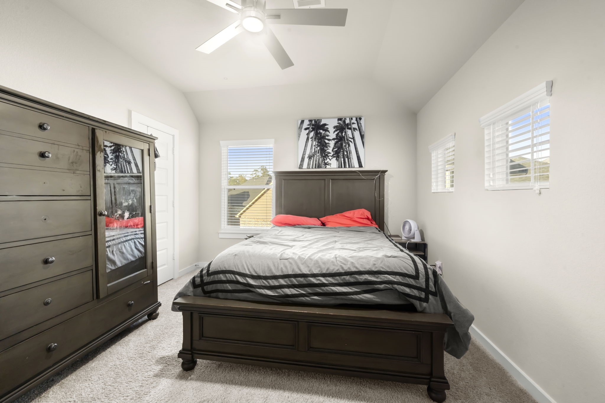 24715 Native Forest Spring, TX 77373 - Photo 31 of 37 This cozy bedroom features a neutral color palette. It has ample natural light from two windows, a ceiling fan, and a modern art piece for a touch of elegance.