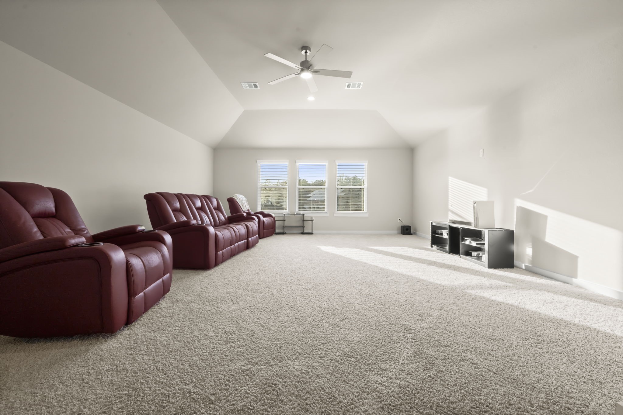 24715 Native Forest Spring, TX 77373 - Photo 32 of 37 This spacious home theater has neutral carpeting, a ceiling fan, and ample natural light from three large windows, creating a perfect setting for entertainment.