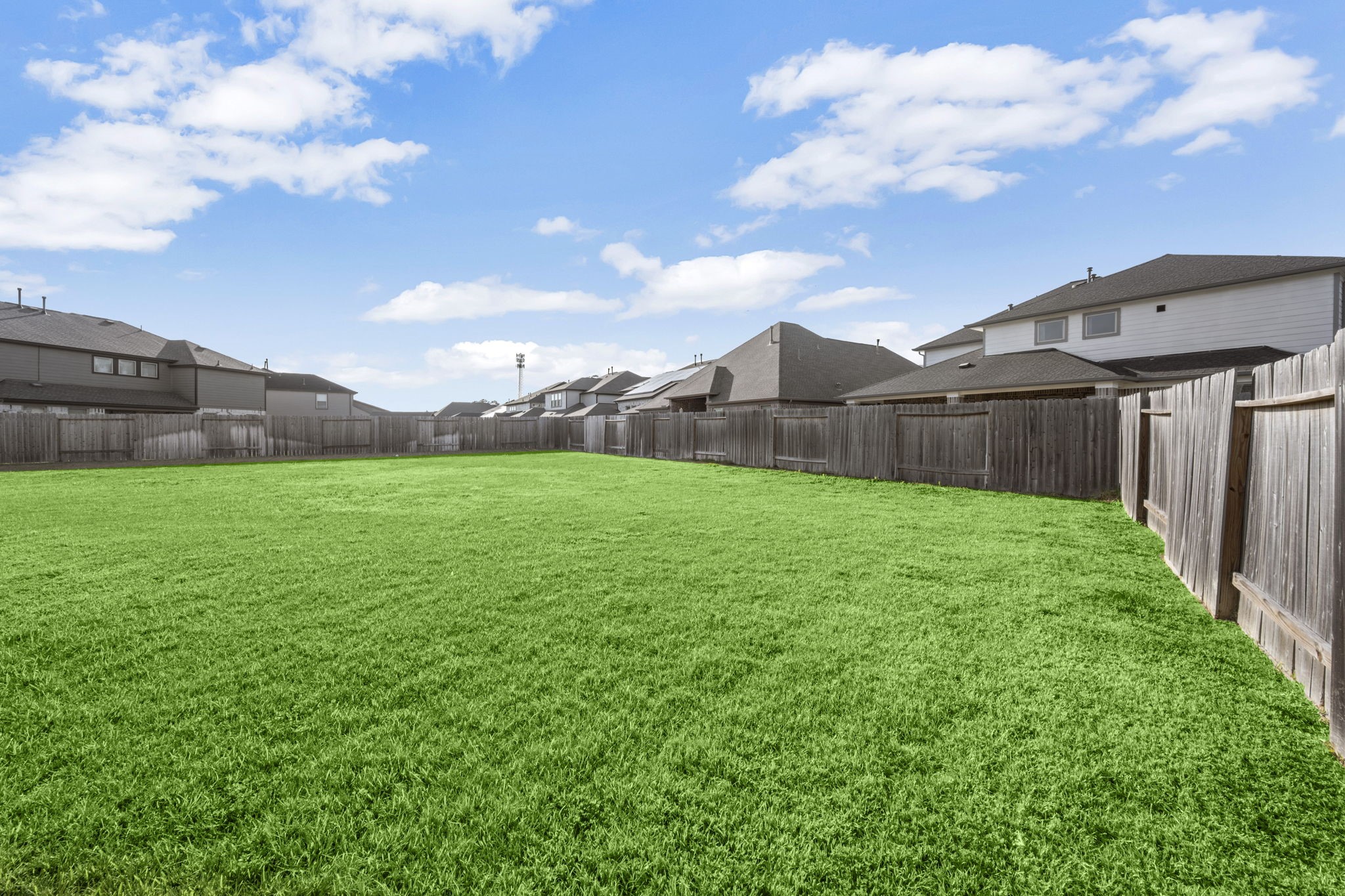 24715 Native Forest Spring, TX 77373 - Photo 33 of 37 Spacious fenced backyard with well-maintained lawn, ideal for outdoor activities and privacy.