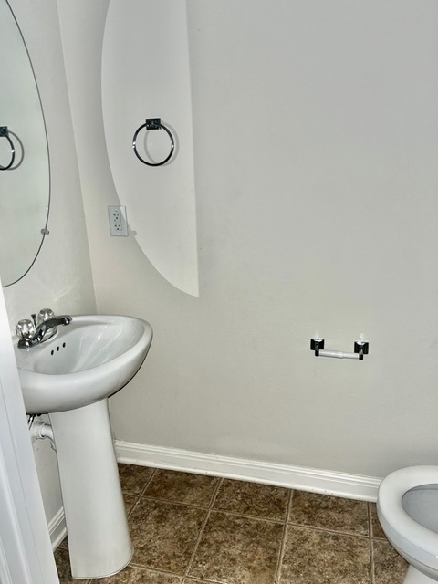 5425 Falling Leaf Lane Austin, TX 78744 - Photo 13 of 28 a bathroom with a sink mirror toilet and vanity