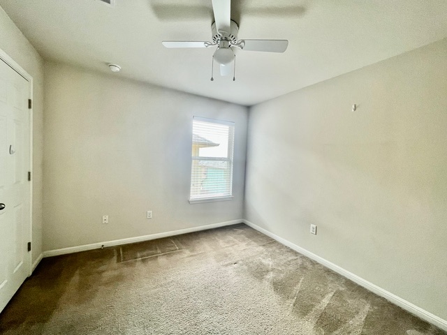 5425 Falling Leaf Lane Austin, TX 78744 - Photo 21 of 28 an empty room with a window and a ceiling fan