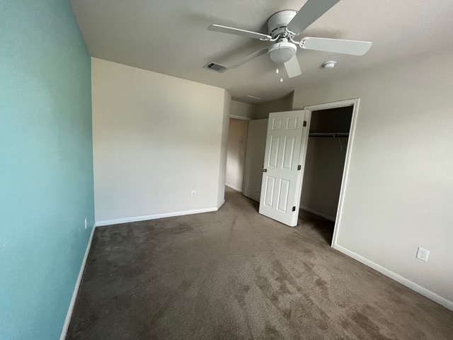 5425 Falling Leaf Lane Austin, TX 78744 - Photo 22 of 28 an empty room with closet and a ceiling fan