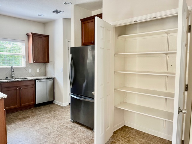5425 Falling Leaf Lane Austin, TX 78744 - Photo 24 of 28 a kitchen with a refrigerator and a sink