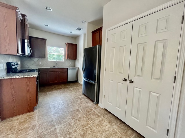 5425 Falling Leaf Lane Austin, TX 78744 - Photo 26 of 28 a kitchen with stainless steel appliances granite countertop a refrigerator and a sink