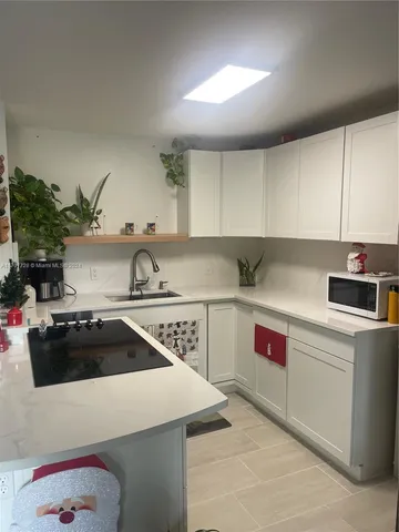 a kitchen with a sink a stove and cabinets