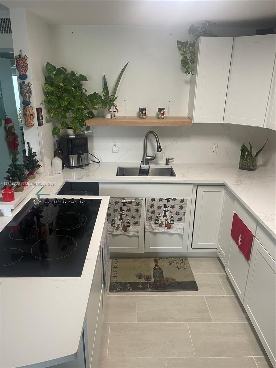 191 Prescott J, Unit 191 Deerfield Beach, FL 33442 - Photo 15 of 18 a kitchen with a stove a microwave and cabinets