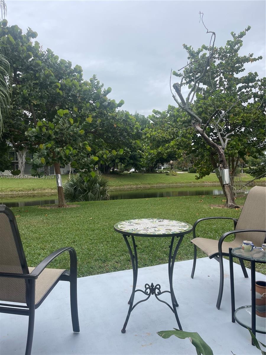 191 Prescott J, Unit 191 Deerfield Beach, FL 33442 - Photo 7 of 18 a view of a chairs and table in the garden