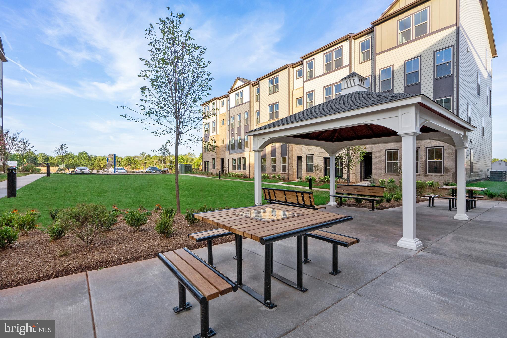 20975 Bluebird Square Sterling, VA 20165 - Photo 20 of 23 a view of a patio with a table and chairs under an umbrella