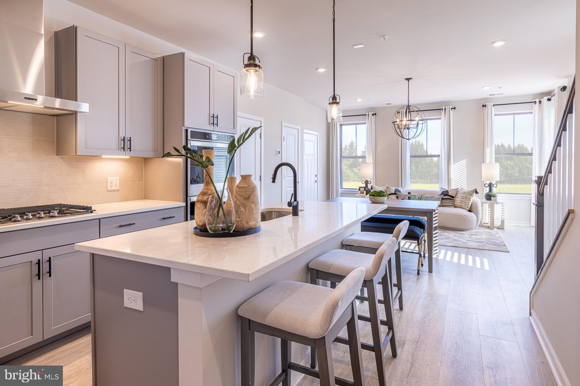 20975 Bluebird Square Sterling, VA 20165 - Photo 2 of 23 a kitchen with kitchen island granite countertop a table chairs stove a sink dishwasher and cabinets