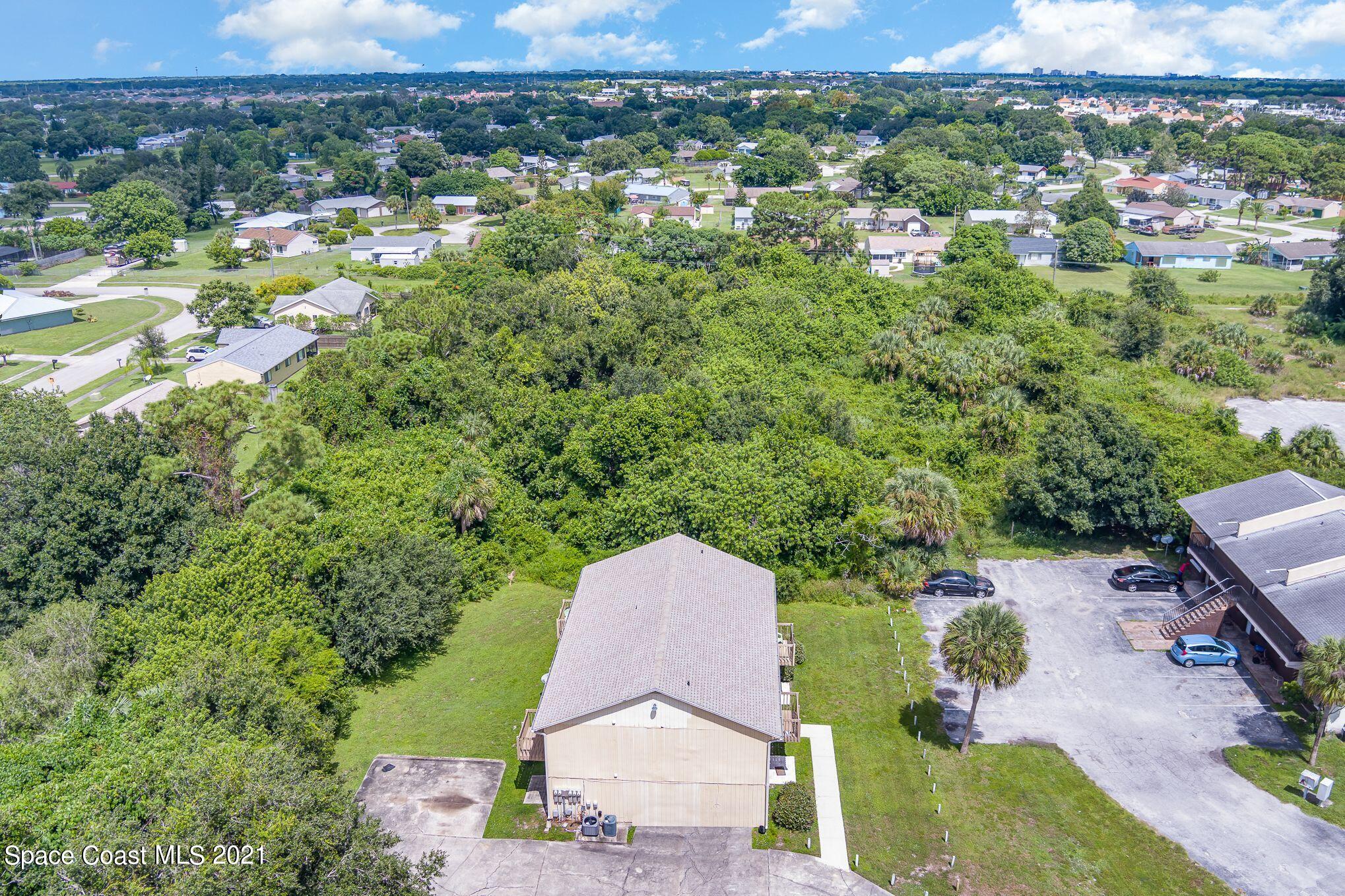 4313 Tree Ridge Lane Northeast Palm Bay, FL 32905 - Photo 3 of 9 an aerial view of a house with a yard and lake view