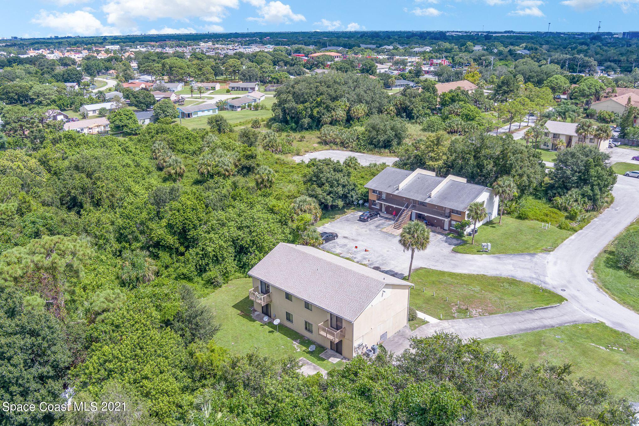 4313 Tree Ridge Lane Northeast Palm Bay, FL 32905 - Photo 4 of 9 an aerial view of a house with a yard