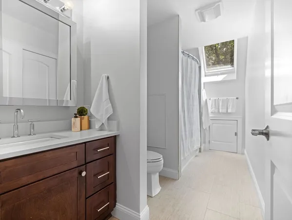 a spacious bathroom with a sink a toilet and a mirror