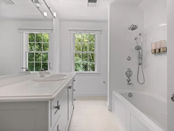 a bathroom with a tub sink and window