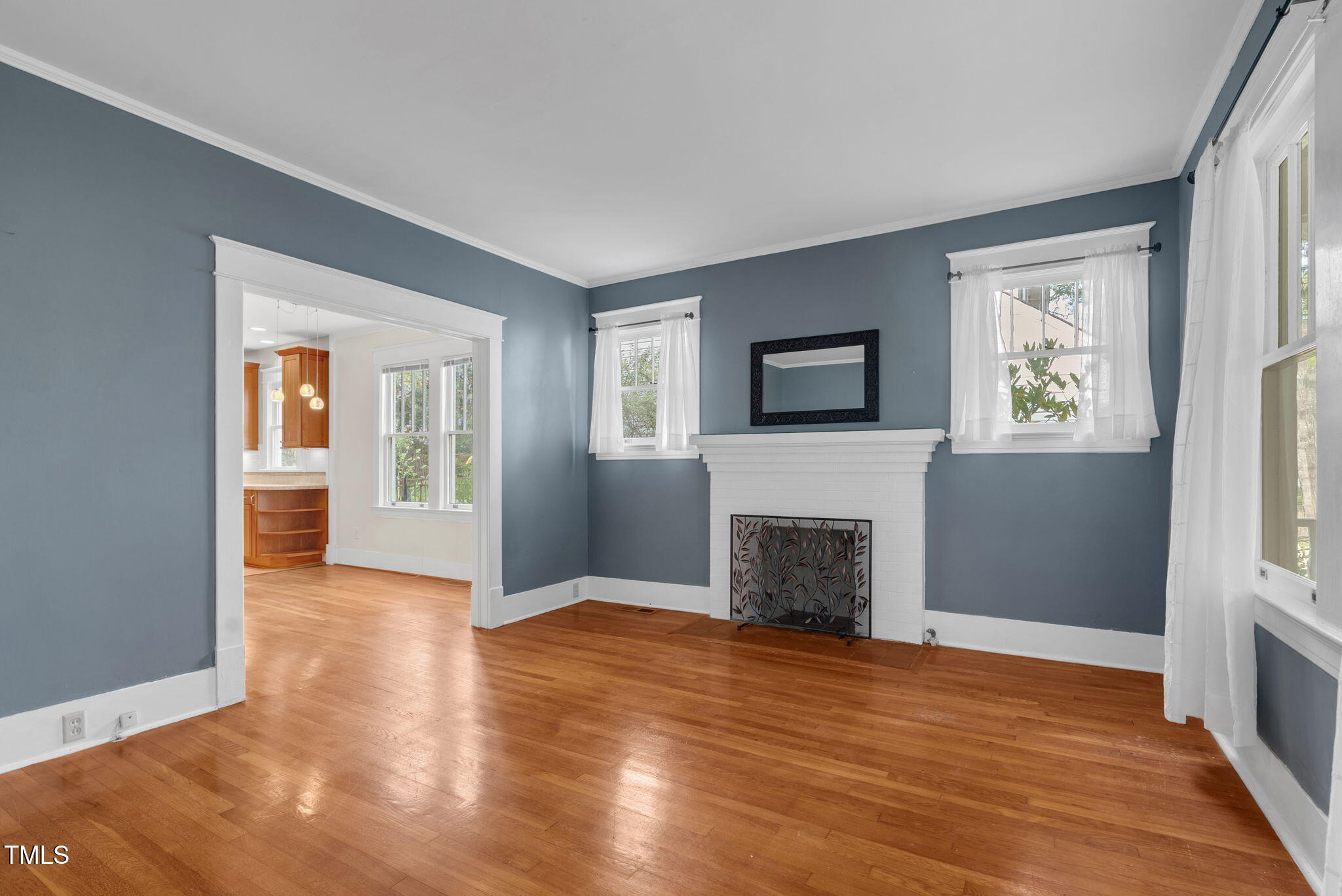 306 Perry Street Raleigh, NC 27608 - Photo 10 of 48 an empty room with windows a fireplace and wooden floor