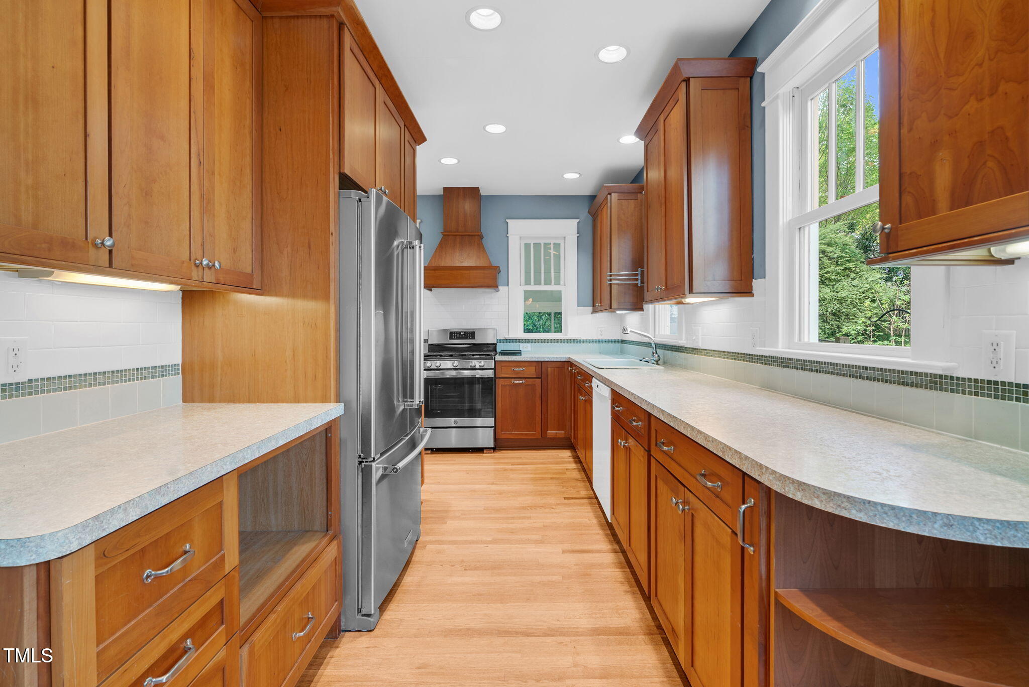 306 Perry Street Raleigh, NC 27608 - Photo 15 of 48 a kitchen with stainless steel appliances a sink dishwasher a stove a refrigerator and a oven with wooden floor