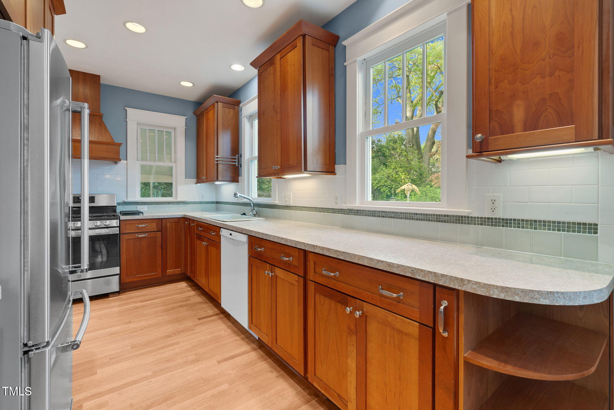 306 Perry Street Raleigh, NC 27608 - Photo 16 of 48 a kitchen with stainless steel appliances granite countertop a sink a stove a refrigerator cabinets and a window