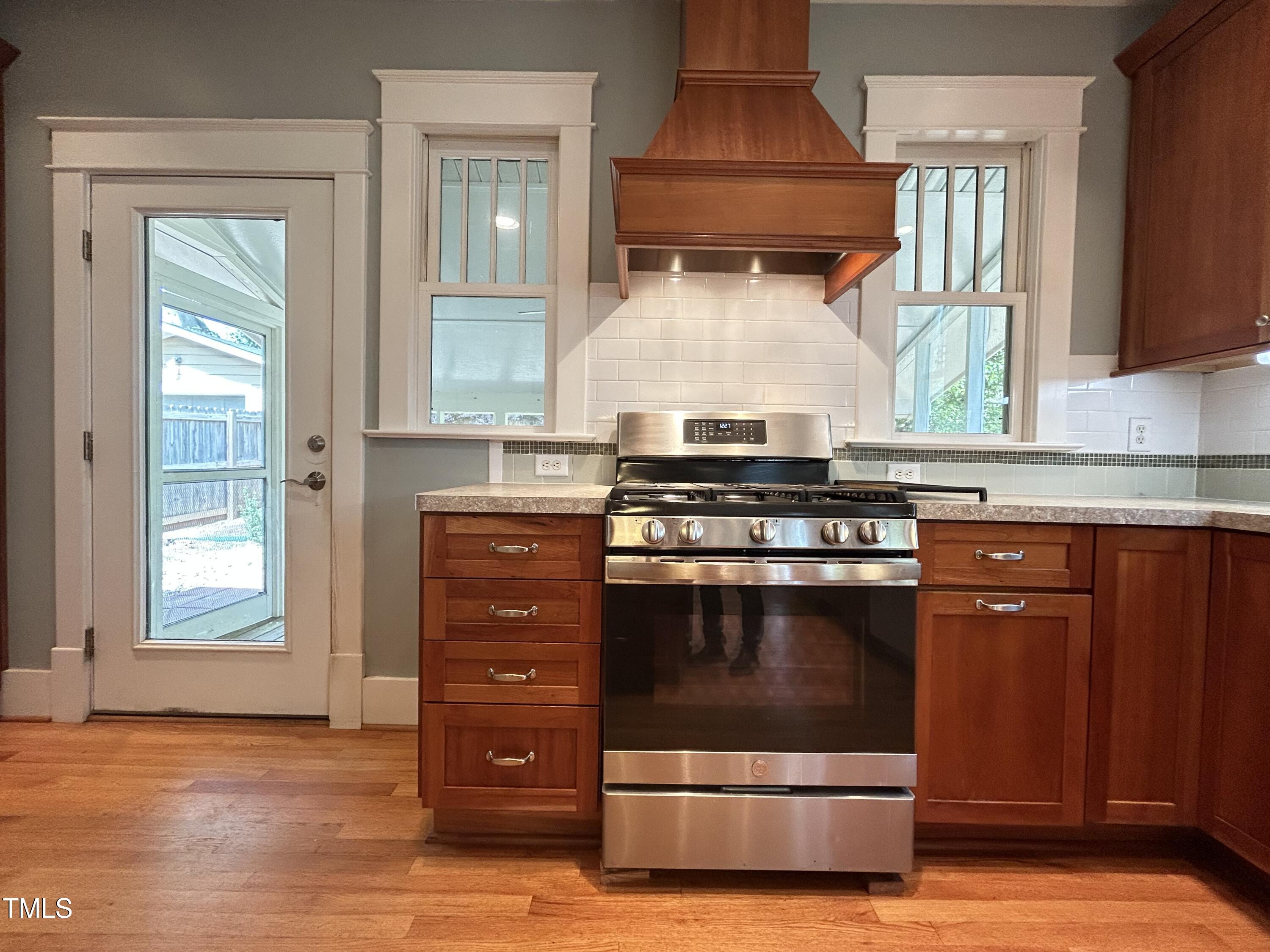 306 Perry Street Raleigh, NC 27608 - Photo 18 of 48 a kitchen with stainless steel appliances granite countertop a stove and a microwave