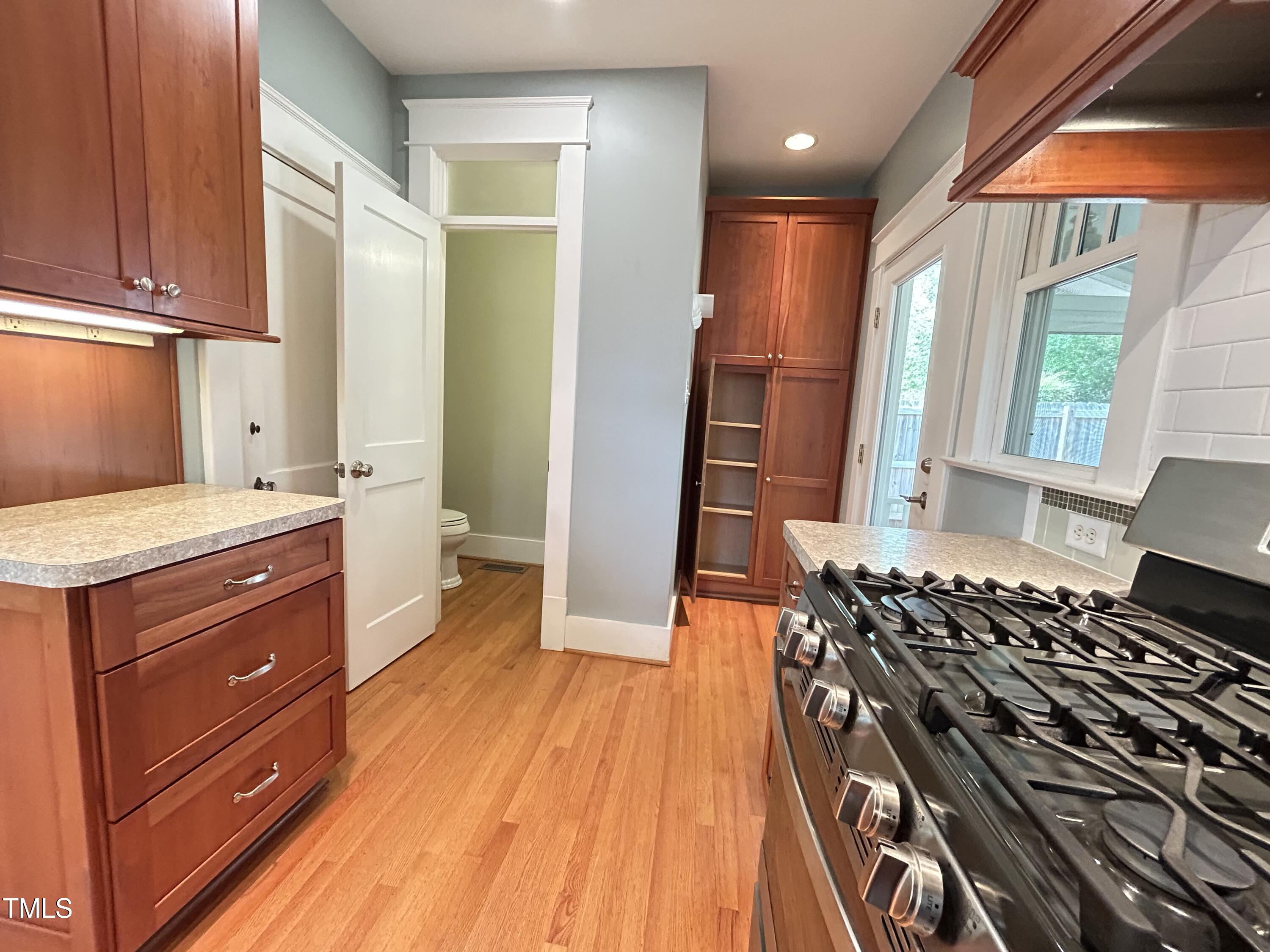 306 Perry Street Raleigh, NC 27608 - Photo 20 of 48 a kitchen with stainless steel appliances granite countertop a stove a sink and a refrigerator