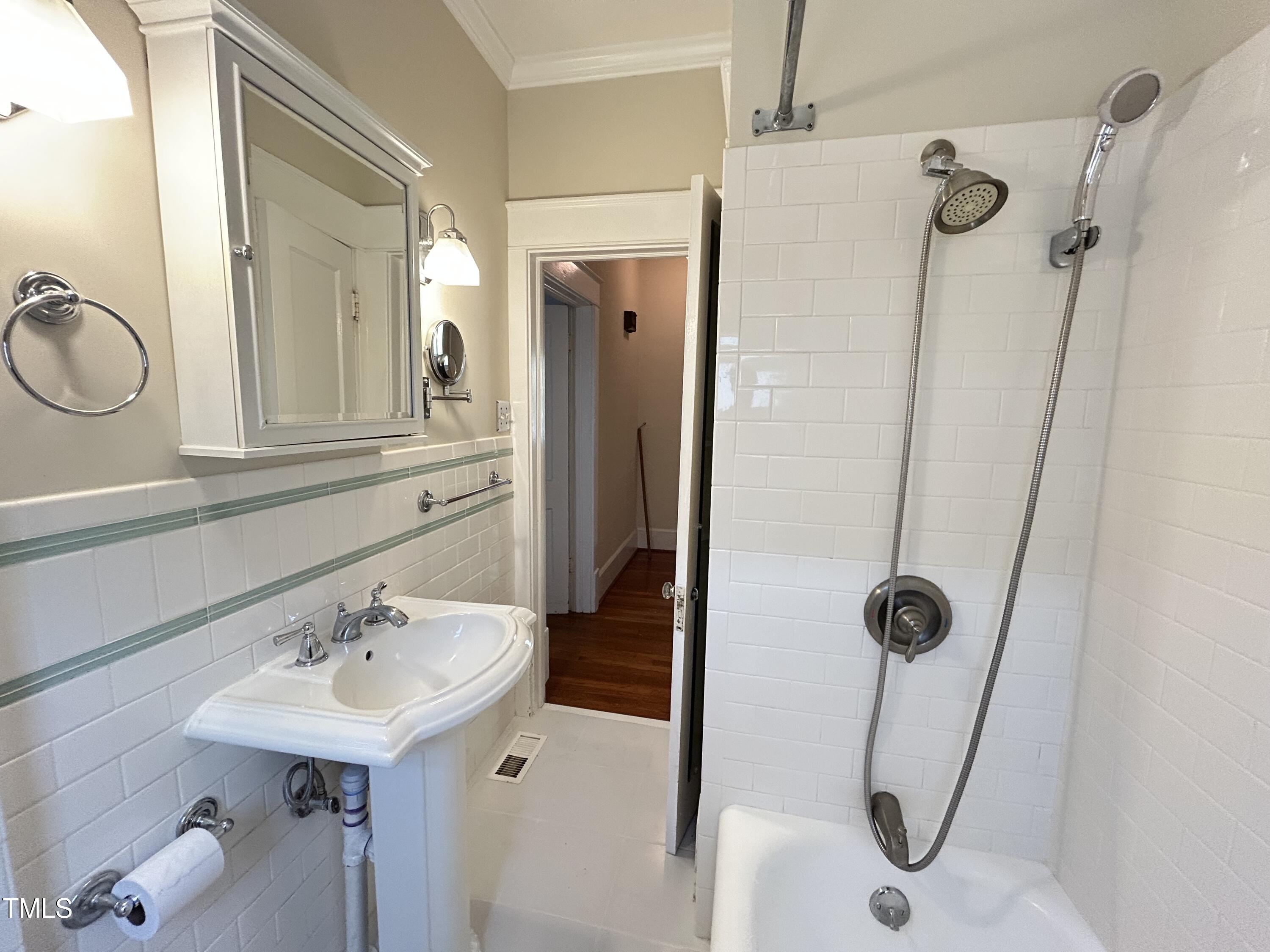 306 Perry Street Raleigh, NC 27608 - Photo 27 of 48 a bathroom with a sink a mirror a glass door a shower and vanity