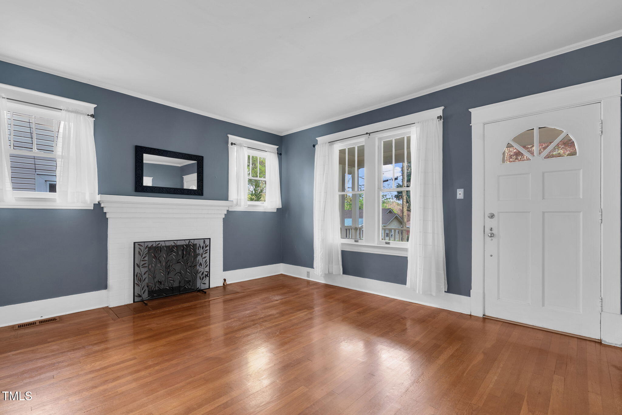 306 Perry Street Raleigh, NC 27608 - Photo 8 of 48 a view of a livingroom with a fireplace wooden floor and window