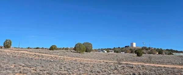 a view of a dry yard with wooden fence