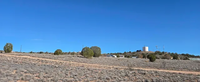 a view of a dry yard with wooden fence