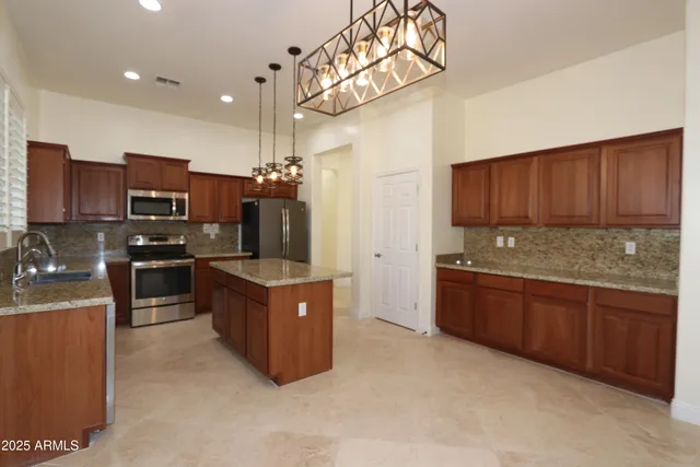 a kitchen with stainless steel appliances granite countertop a stove refrigerator and cabinets