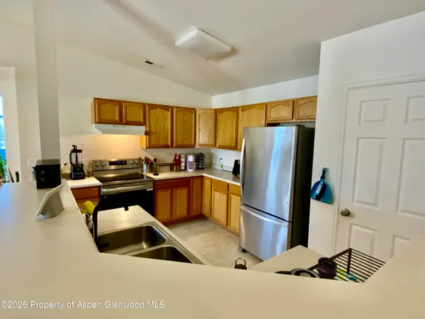 a kitchen with stainless steel appliances granite countertop a refrigerator a stove a sink and a refrigerator