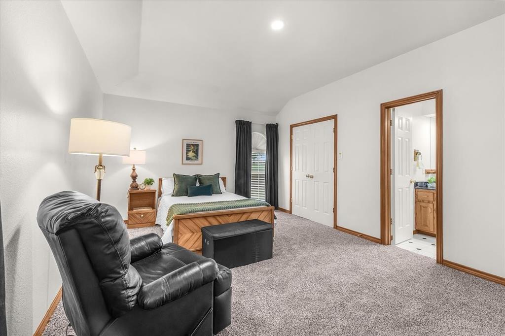 353 Hidden Meadow Court Rhome, TX 76078 - Photo 11 of 28 Bedroom with carpet floors, vaulted ceiling, and ensuite bath