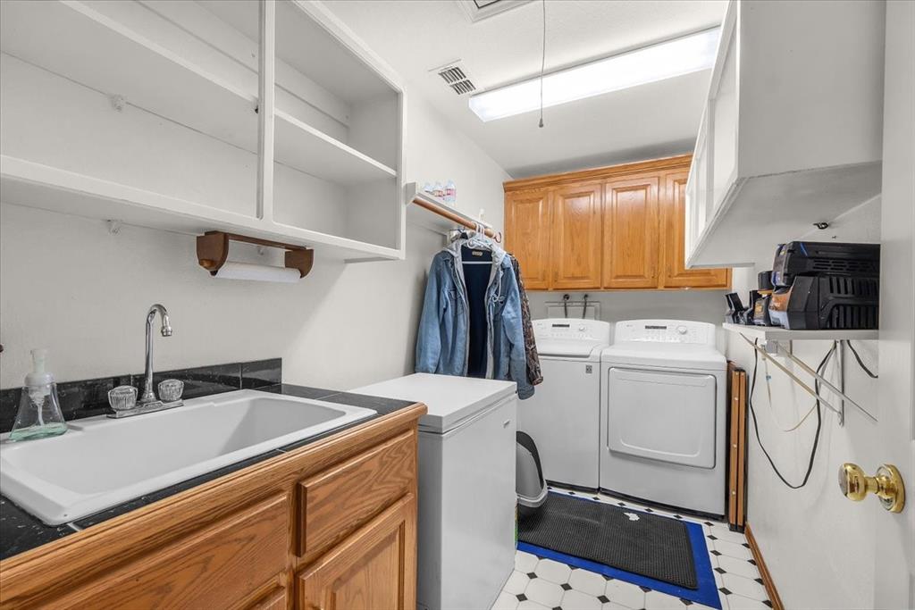 353 Hidden Meadow Court Rhome, TX 76078 - Photo 14 of 28 Laundry room with cabinet space, light floors, and washing machine and dryer