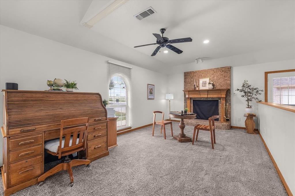 353 Hidden Meadow Court Rhome, TX 76078 - Photo 7 of 28 Home office featuring light colored carpet, a ceiling fan, recessed lighting, and a brick fireplace