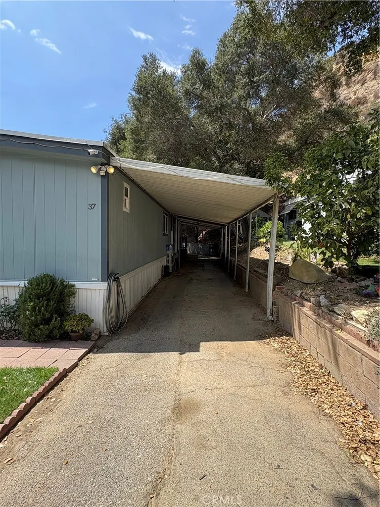 23500 The Old Road, Unit 37 Newhall, CA 91321 - Photo 3 of 22 a view of a patio with table and chairs with wooden fence and plants