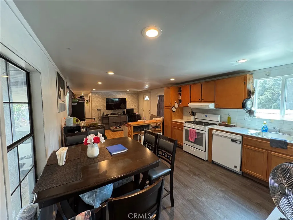 23500 The Old Road, Unit 37 Newhall, CA 91321 - Photo 7 of 22 a kitchen with a dining table chairs wooden floor and appliances